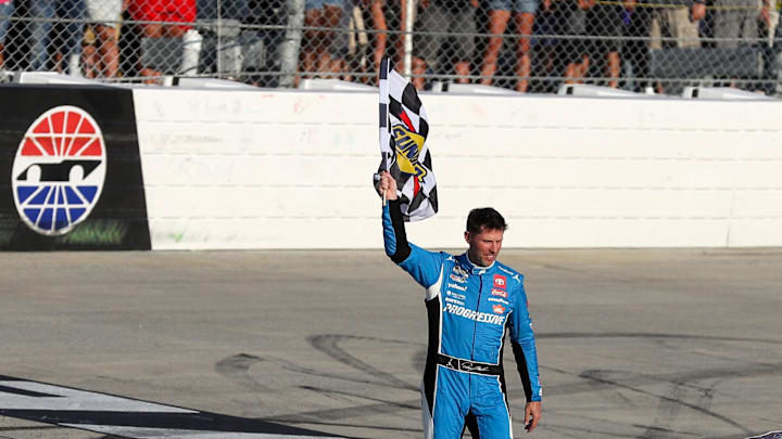 Jul 20, 2025; Dover, Delaware, USA; NASCAR Cup Series driver Denny Hamlin waves the checkered flag after winning the Autotrader EchoPark Automotive 400 at Dover Motor Speedway. Mandatory Credit: Matthew O'Haren-Imagn Images Jul 20, 2025; Dover, Delaware, USA; NASCAR Cup Series driver Denny Hamlin waves the checkered flag after winning the Autotrader EchoPark Automotive 400 at Dover Motor Speedway. Mandatory Credit: Matthew O'Haren-Imagn Images