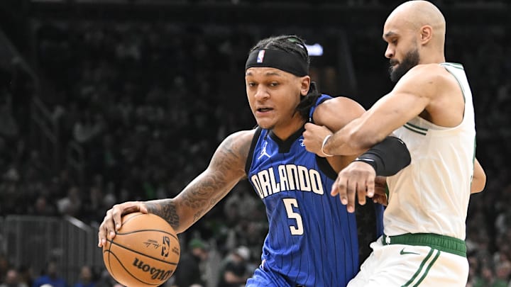 Jan 17, 2025; Boston, Massachusetts, USA; Orlando Magic forward Paolo Banchero (5) dribbles the ball against Boston Celtics guard Derrick White (9) during the first half at TD Garden. Mandatory Credit: Eric Canha-Imagn Images