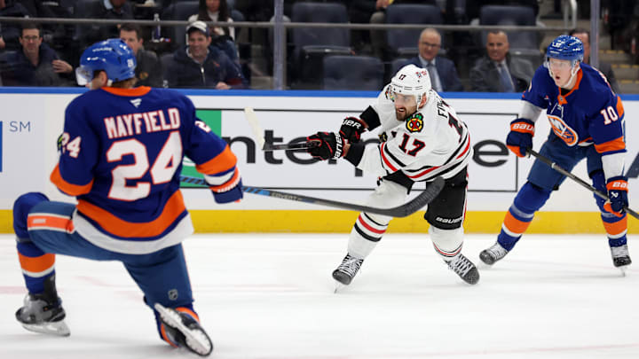 Dec 12, 2024; Elmont, New York, USA; Chicago Blackhawks left wing Nick Foligno (17) follows through on a shot against New York Islanders right wing Simon Holmstrom (10) and defenseman Scott Mayfield (24) during the third period at UBS Arena. Mandatory Credit: Brad Penner-Imagn Images Dec 12, 2024; Elmont, New York, USA; Chicago Blackhawks left wing Nick Foligno (17) follows through on a shot against New York Islanders right wing Simon Holmstrom (10) and defenseman Scott Mayfield (24) during the third period at UBS Arena. Mandatory Credit: Brad Penner-Imagn Images