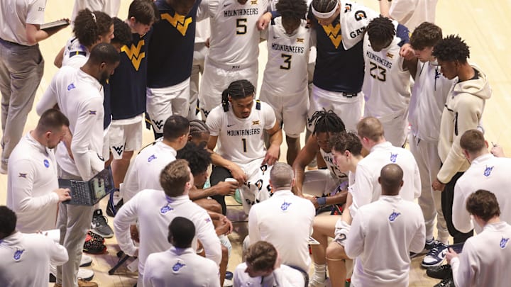 Feb 18, 2026; Morgantown, West Virginia, USA; West Virginia Mountaineers players listen to West Virginia Mountaineers head coach Ross Hodge during a timeout during the second half against the Utah Utes at Hope Coliseum. Mandatory Credit: Ben Queen-Imagn Images