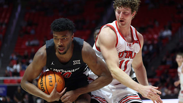 Jan 28, 2025; Salt Lake City, Utah, USA; Cincinnati Bearcats guard Josh Reed (10) rebounds the ball against Utah Utes forward Caleb Lohner (11) during the second half at Jon M. Huntsman Center. Mandatory Credit: Rob Gray-Imagn Images