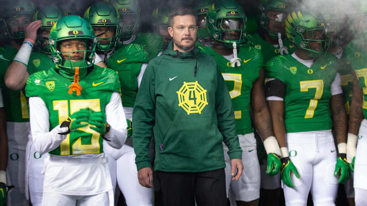 Oregon head coach Dan Lanning, center, waits to take the field with his team for their game against