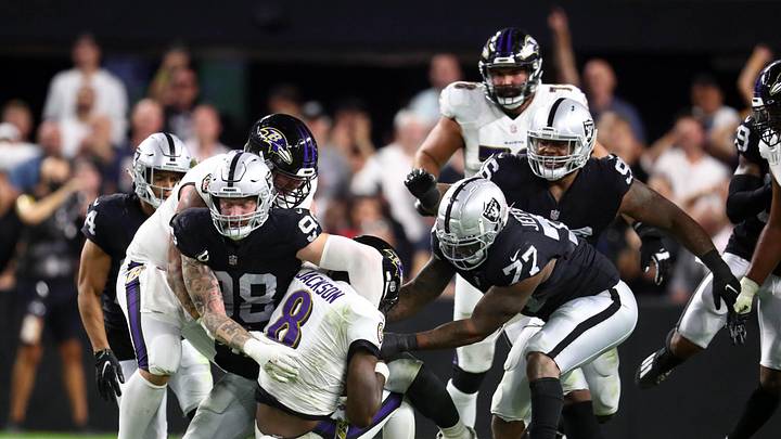 Sep 13, 2021; Paradise, Nevada, USA;Baltimore Ravens quarterback Lamar Jackson (8) is brought down by Las Vegas Raiders defensive end Maxx Crosby (98) and defensive end Quinton Jefferson (77)  during the second half at Allegiant Stadium. Mandatory Credit: Mark J. Rebilas-Imagn Images