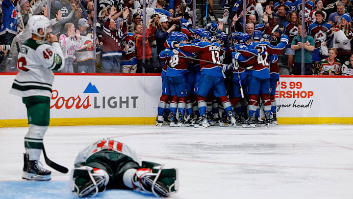 May 13, 2026; Denver, Colorado, USA; Colorado Avalanche players celebrate after the game as Minnesota Wild goaltender Jesper Wallstedt (30) lies on the ice next to defenseman Jared Spurgeon (46) in game five of the second round of the 2026 Stanely Cup Playoffs at Ball Arena. Mandatory Credit: Isaiah J. Downing-Imagn Images