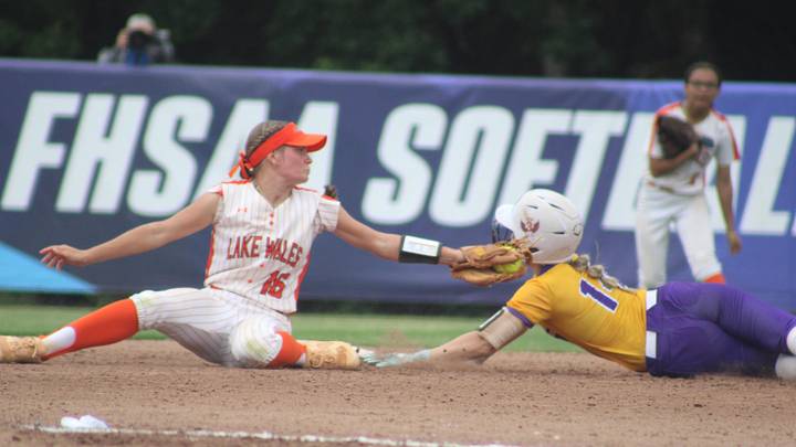 Lake Wales shortstop Sydney Greene (16) tags Columbia runner Marlee Hunt (14) on a steal attempt during the FHSAA Class 4A high school softball championship at Boombah-Soldiers Creek Park in Longwood, Florida, on May 23, 2026. Hunt reached in time but was called out for leaving first too soon. [Clayton Freeman/Florida Times-Union]