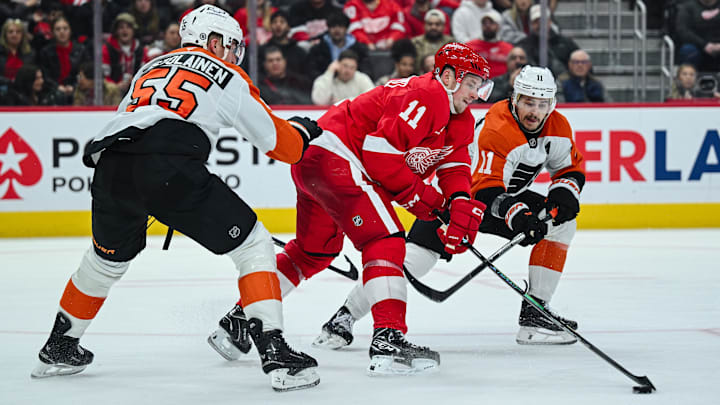 Dec 18, 2024; Detroit, Michigan, USA; Detroit Red Wings right wing Vladimir Tarasenko (11) battles for the puck abasing Philadelphia Flyers defenseman Rasmus Ristolainen (55) and right wing Travis Konecny (11) during the second period at Little Caesars Arena. Mandatory Credit: Tim Fuller-Imagn Images