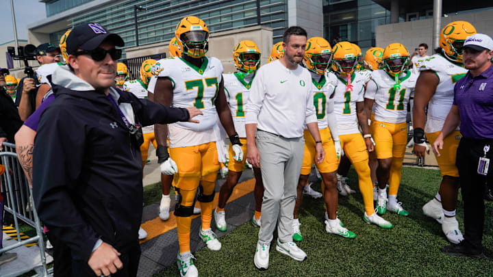 Sep 13, 2025; Evanston, Illinois, USA; Oregon Ducks head coach Dan Lanning leads his team on the field against the Northwestern Wildcats at Northwestern Medicine Field at Martin Stadium. Mandatory Credit: David Banks-Imagn Images