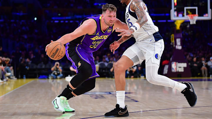 Los Angeles Lakers guard Luka Doncic dribbles the ball against Dallas Mavericks forward P.J. Washington.
