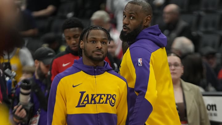 Los Angeles Lakers forward LeBron James (right) looks back at guard Bronny James (left) warm-up before the start of the game against the Toronto Raptors at Scotiabank Arena.