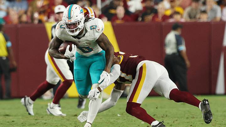 Miami Dolphins running back Ollie Gordon II (0) runs with the ball as Washington Commanders cornerback Car'lin Vigers (37) makes a tackle during the second half at Northwest Stadium. Miami Dolphins running back Ollie Gordon II (0) runs with the ball as Washington Commanders cornerback Car'lin Vigers (37) makes a tackle during the second half at Northwest Stadium.