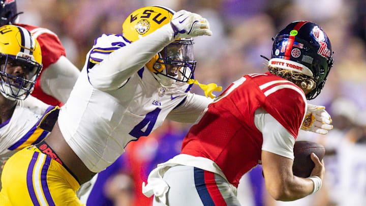 Oct 12, 2024; Baton Rouge, Louisiana, USA; LSU Tigers defensive end Bradyn Swinson (4) sacks Mississippi Rebels quarterback Jaxson Dart (2) during the second half at Tiger Stadium. Mandatory Credit: Stephen Lew-Imagn Images Oct 12, 2024; Baton Rouge, Louisiana, USA; LSU Tigers defensive end Bradyn Swinson (4) sacks Mississippi Rebels quarterback Jaxson Dart (2) during the second half at Tiger Stadium. Mandatory Credit: Stephen Lew-Imagn Images
