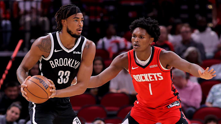 Oct 27, 2025; Houston, Texas, USA; Brooklyn Nets center Nic Claxton (33) handles the ball against Houston Rockets guard Amen Thompson (1) during the first quarter at Toyota Center. Mandatory Credit: Erik Williams-Imagn Images
