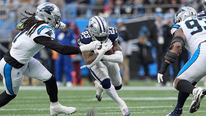 Dec 15, 2024; Charlotte, North Carolina, USA; Dallas Cowboys running back Rico Dowdle (23) runs against Carolina Panthers linebacker Jadeveon Clowney (7) during the second half at Bank of America Stadium. Mandatory Credit: Jim Dedmon-Imagn Images Dec 15, 2024; Charlotte, North Carolina, USA; Dallas Cowboys running back Rico Dowdle (23) runs against Carolina Panthers linebacker Jadeveon Clowney (7) during the second half at Bank of America Stadium. Mandatory Credit: Jim Dedmon-Imagn Images
