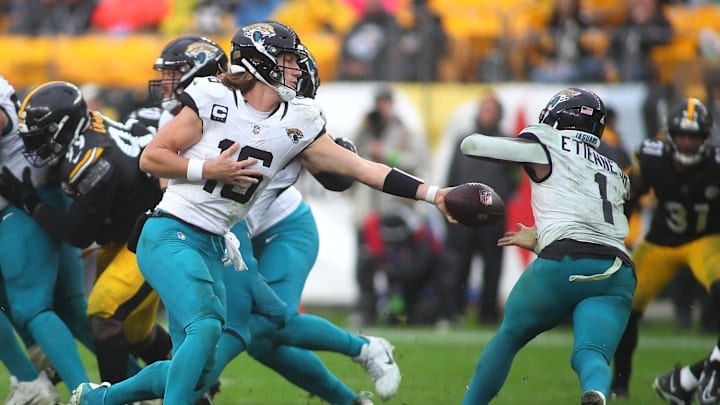 Jacksonville Jaguars Trevor Lawrence (16) hands the ball off to Travis Etienne Jr. (1) during the