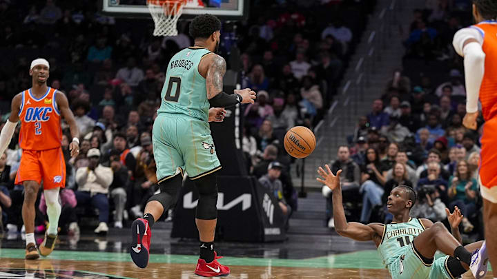 Dec 28, 2024; Charlotte, North Carolina, USA  Charlotte Hornets forward Moussa Diabate (14) grabs an errant loose ball and tosses it to forward Miles Bridges (0) for the fast break against the Oklahoma City Thunder during the second half at Spectrum Center. Mandatory Credit: Jim Dedmon-Imagn Images