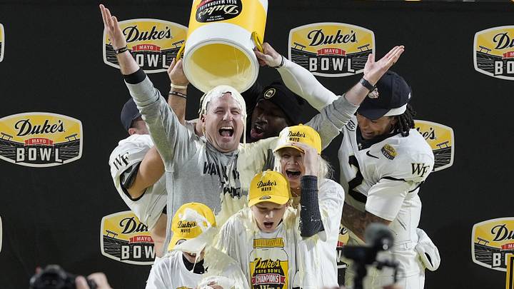 Jan 2, 2026; Charlotte, NC, USA;  Wake Forest Demon Deacons defensive back Nick Andersen (45) and Wake Forest Demon Deacons quarterback Robby Ashford (2) dump mayo on  head coach Jake Dickert and his family receive the traditional mayo dump after Wake Forest Demon Deacons win at Bank of America Stadium. Mandatory Credit: Jim Dedmon-Imagn Images