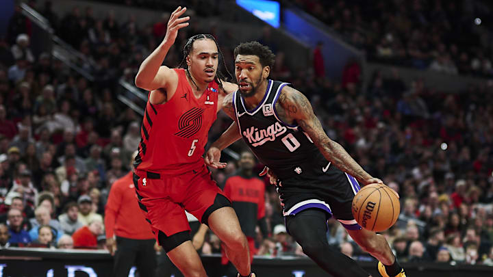 Feb 6, 2025; Portland, Oregon, USA; Sacramento Kings guard Malik Monk (0) drives to the basket during the second half against Portland Trail Blazers guard Dalano Banton (5) at Moda Center. Mandatory Credit: Troy Wayrynen-Imagn Images