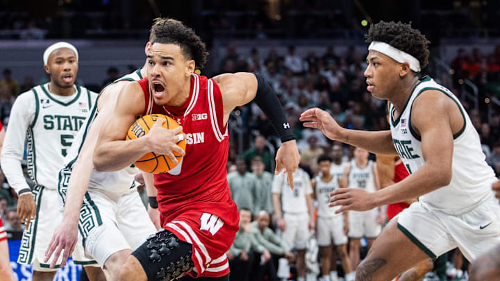 Mar 15, 2025; Indianapolis, IN, USA; Wisconsin Badgers guard John Tonje (9) shoots the ball while Michigan State Spartans guard Jeremy Fears Jr. (1) defends in the second half  at Gainbridge Fieldhouse. Mandatory Credit: Trevor Ruszkowski-Imagn Images