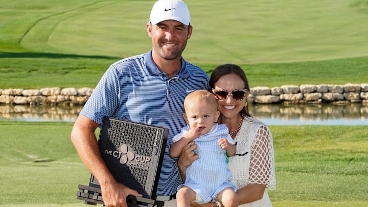Scottie Scheffler with his wife Meredith and son Bennett pose with the winner's trophy during the final round of the THE CJ CUP Byron Nelson golf tournament.