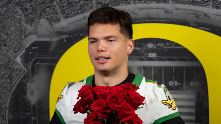 Oregon quarterback Dillon Gabriel holds a bouquet of roses while filming videos during media day for the Oregon Ducks in Los Angeles ahead of the Rose Bowl Monday, Dec. 30, 2024.