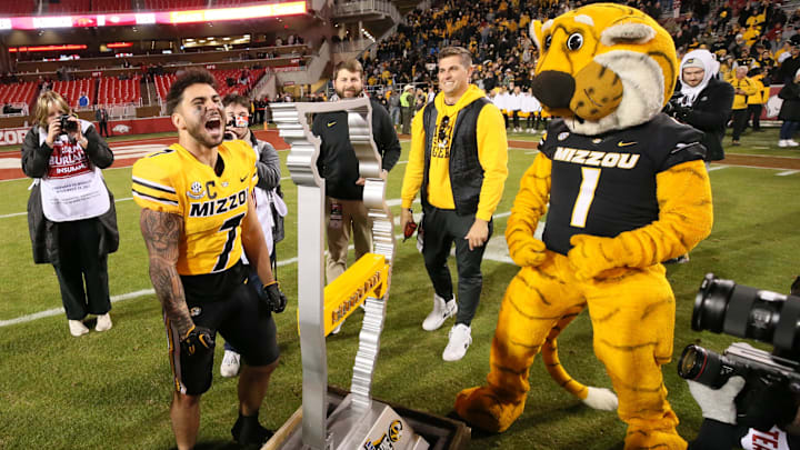 Missouri Tigers running back Cody Schrader (7) celebrates after placing the Missouri line into the Battle Line Trophy at the end of the game against the Arkansas Razorbacks at Donald W. Reynolds Razorback Stadium. Missouri won 48-14. Mandatory Credit: Nelson Chenault-Imagn Images
