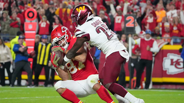 Oct 27, 2025; Kansas City, Missouri, USA; Kansas City Chiefs tight end Travis Kelce (87) makes a reception for a touchdown defended by Washington Commanders safety Darnell Savage (25) during the third quarter of the game at GEHA Field at Arrowhead Stadium. Mandatory Credit: Denny Medley-Imagn Images