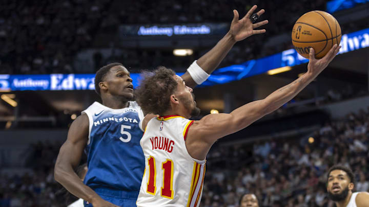 Apr 12, 2024; Minneapolis, Minnesota, USA; Atlanta Hawks guard Trae Young (11) drives to the basket past Minnesota Timberwolves guard Anthony Edwards (5) in the first half at Target Center.