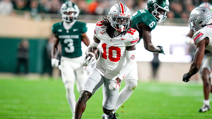 Sep 28, 2024; East Lansing, Michigan, USA; Ohio State Buckeyes cornerback Denzel Burke (10) returns the ball after intercepting a pass in the second half at Spartan Stadium on Saturday.