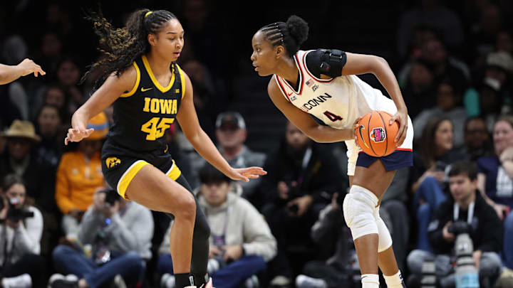 Dec 20, 2025; Brooklyn, New York, USA; UConn Huskies forward Blanca Quiñonez (4) looks to pass the ball against Iowa Hawkeyes forward Hannah Stuelke (45) during the first half at Barclays Center. Mandatory Credit: Pamela Smith-Imagn Images