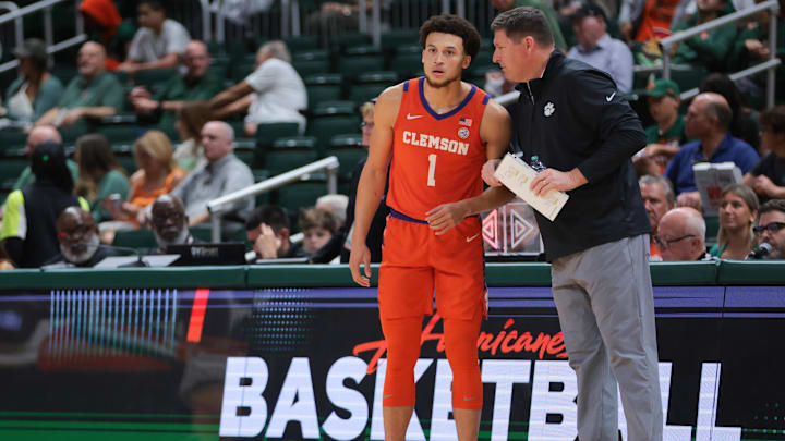 Dec 7, 2024; Coral Gables, Florida, USA; Clemson Tigers head coach Brad Brownell talks to guard Chase Hunter (1) during the first half against the Miami Hurricanes at Watsco Center. Mandatory Credit: Sam Navarro-Imagn Images