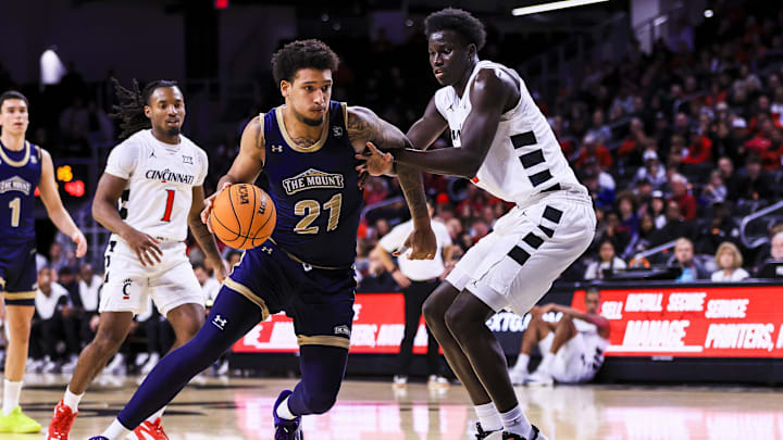 Nov 16, 2025; Cincinnati, Ohio, USA; Mount St. Mary's Mountaineers forward Luke McEldon (21) drives to the basket against Cincinnati Bearcats center Moustapha Thiam (52) in the second half at Fifth Third Arena. Mandatory Credit: Katie Stratman-Imagn Images