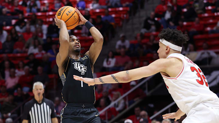 Feb 21, 2026; Salt Lake City, Utah, USA; UCF Knights guard Themus Fulks (1) goes up for a shot against Utah Utes forward James Okonkwo (32) during the first half at Jon M. Huntsman Center. Mandatory Credit: Rob Gray-Imagn Images