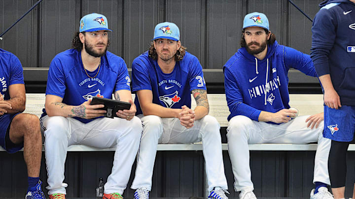 Blue Jays pitchers sit on a bench in blue Blue Jays gea