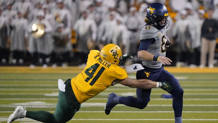 Nov 25, 2023; Waco, Texas, USA; West Virginia Mountaineers quarterback Garrett Greene (6) carries the ball as Baylor Bears linebacker Brooks Miller (41) defends during the second half at McLane Stadium. Mandatory Credit: Raymond Carlin III-Imagn Images