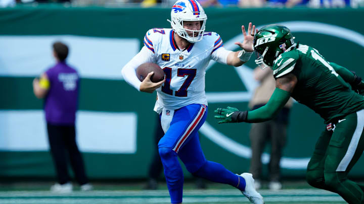Buffalo Bills quarterback Josh Allen tries to prevent New York Jets linebacker Jermaine Johnson from tackling him.
