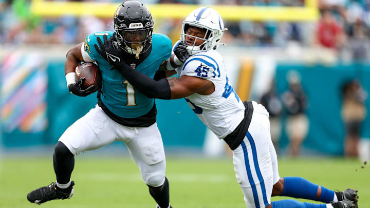 Oct 6, 2024; Jacksonville, Florida, USA; Jacksonville Jaguars running back Travis Etienne Jr. (1) holds off Indianapolis Colts linebacker E.J. Speed (45) in the first quarter at EverBank Stadium. Mandatory Credit: Nathan Ray Seebeck-Imagn Images