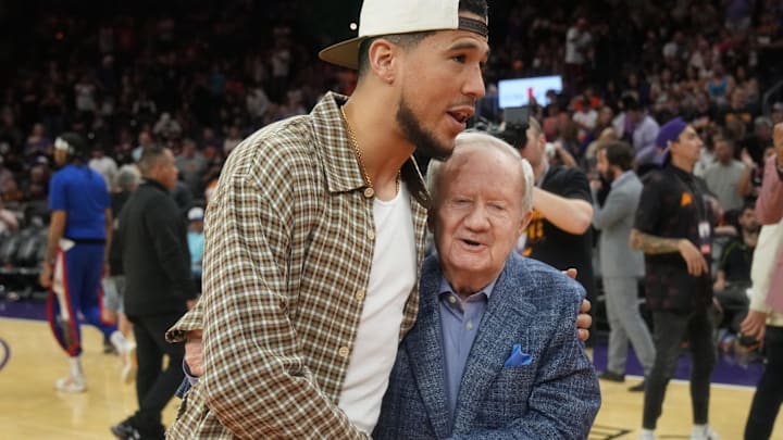 Broadcaster Al McCoy is embraced by Suns shooting guard Devin Booker after being honored for 51 seasons as \"the Voice of the Suns\" during halftime against the Los Angeles Clippers on April 9, 2023, at Footprint Center in Phoenix.

Al McCoy and Devin Booker embrace