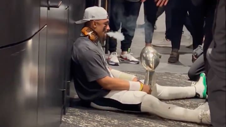 Jalen Hurts smoking a cigar with the Lombardi trophy.