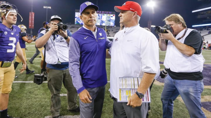 Washington coach Chris Petersen embraces his Fresno State counterpart Jeff Tedford following the Huskies' 48-16 victory at Husky Stadium in 2017.