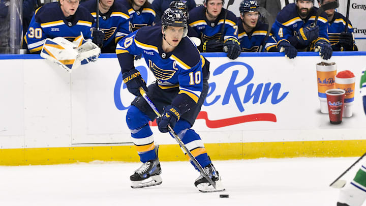 Mar 20, 2025; St. Louis, Missouri, USA;  St. Louis Blues center Brayden Schenn (10) controls the puck against the Vancouver Canucks during overtime at Enterprise Center. Mandatory Credit: Jeff Curry-Imagn Images