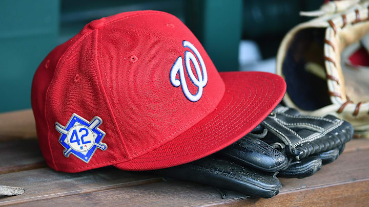 Red Washington Nationals hat on top of black glove