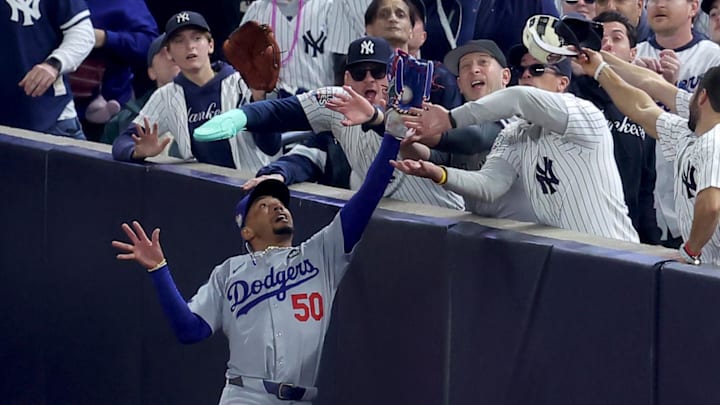 Bettsmakes a catch in foul territory as a New York Yankees fan interferes during the first inning in Game 4 of the World Series.