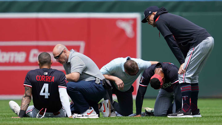 May 15, 2025; Baltimore, Maryland, USA; Minnesota Twins outfielder Byron Buxton (25) and shortstop Carlos Correa (4) remain on the ground following a collision while chasing the ball during the third inning against the Baltimore Orioles at Oriole Park at Camden Yards. Mandatory Credit: Mitch Stringer-Imagn Images