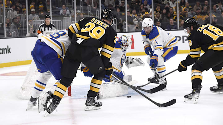 Oct 30, 2025; Boston, Massachusetts, USA; Buffalo Sabres goaltender Alex Lyon (34) makes a save in front of Boston Bruins center Morgan Geekie (39) and defenseman Bowen Byram (4) during the first period at TD Garden. Mandatory Credit: Bob DeChiara-Imagn Images