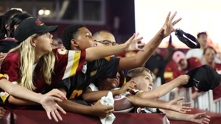 Aug 14, 2026; Landover, Maryland, USA; Young Washington Commanders fans catch a player's headband after the Commanders’ game against the Miami Dolphins at Northwest Stadium. Mandatory Credit: Amber Searls-Imagn Images