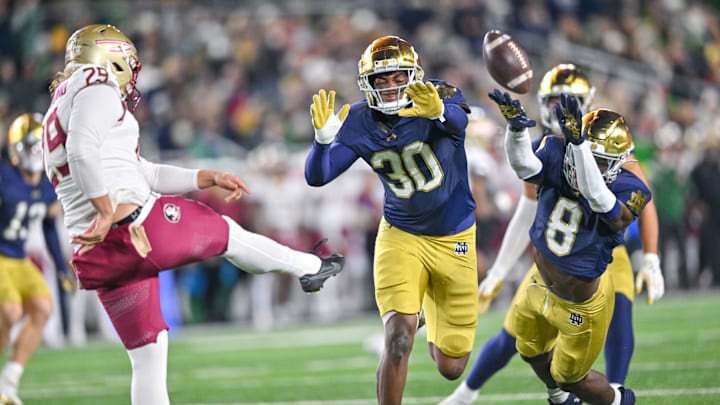 Nov 9, 2024; South Bend, Indiana, USA; Notre Dame Fighting Irish defensive lineman Bryce Young (30) and safety Adon Shuler (8) rush a punt by Florida State Seminoles punter Alex Mastromanno (29) in the second quarter at Notre Dame Stadium. 