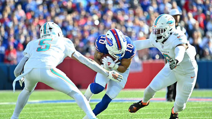 Nov 3, 2024; Orchard Park, New York, USA; Buffalo Bills wide receiver Khalil Shakir (10) ducks to try to avoid a tackle by Miami Dolphins cornerback Jalen Ramsey (5) and linebacker Anthony Walker Jr. (6) in the first quarter at Highmark Stadium. Mandatory Credit: Mark Konezny-Imagn Images