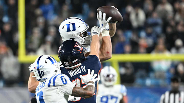 Dec 6, 2025; Charlotte, NC, USA; Duke Blue Devils linebacker Luke Mergott (34) intercepts a pass intended for Virginia Cavaliers wide receiver Eli Wood (82) as Duke Blue Devils cornerback Chandler Rivers (0) helps defend to end the game in overtime during the  ACC Championship game at Bank of America Stadium. Mandatory Credit: Bob Donnan-Imagn Images
