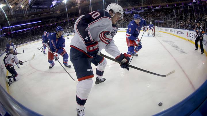 Mar 2, 2026; New York, New York, USA; Columbus Blue Jackets left wing Dmitri Voronkov (10) fights for the puck against New York Rangers defensemen Matthew Robertson (29) and Vincent Iorio (6) during the first period at Madison Square Garden. Mandatory Credit: Brad Penner-Imagn Images