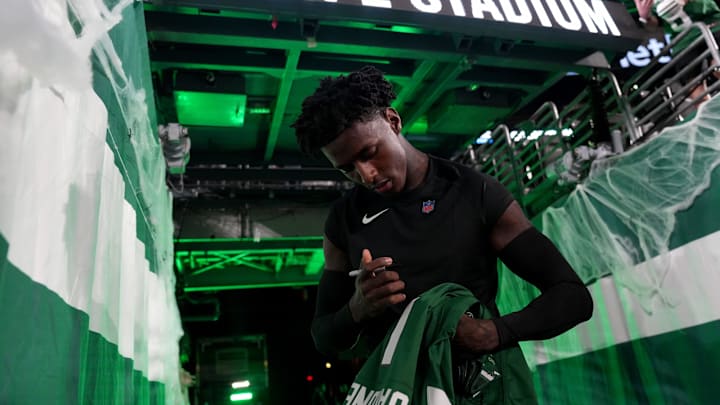 New York Jets cornerback Sauce Gardner (1) signs an autograph for a fan before the game, Thursday, October 31, 2024, in East Rutherford.